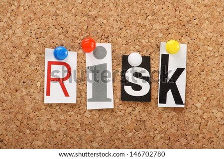 The word Risk in cut out magazine letters pinned to a cork notice board. Taking a Risk may apply to business ventures, games of chance or life goals.