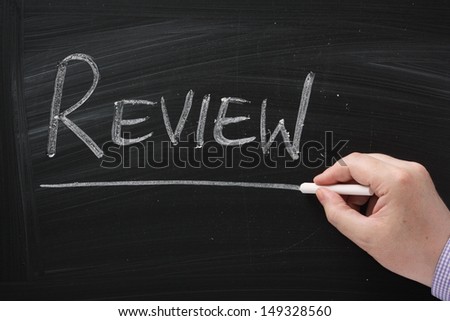 Hand writing the word Review on a blackboard. it is important to review and measure the success of your business plans,life goals and relationships in order to decide the way forward