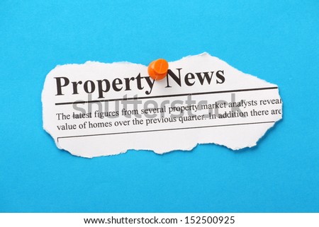 Newspaper Clipping for Property News pinned to a blue paper background