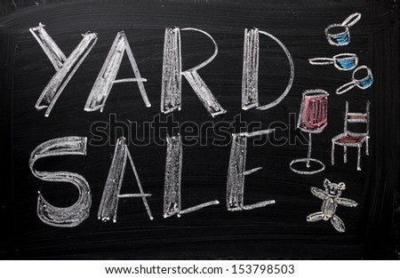 An advertisement or announcement of a Yard Sale on a used blackboard. Yard sales are a traditional way to make money and clear out unwanted or old belongings from your home.