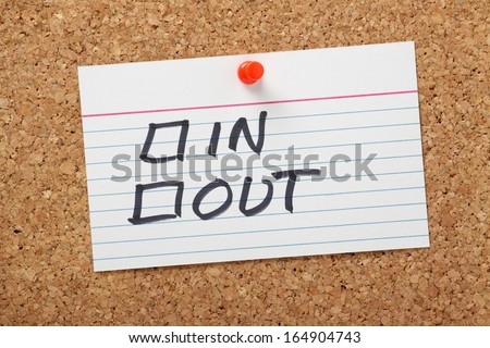 In or Out tick boxes on a white note card pinned to a cork notice board