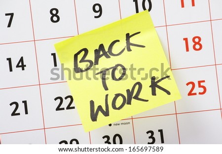 The phrase Back To Work on a yellow sticky paper note stuck to a wall calendar background