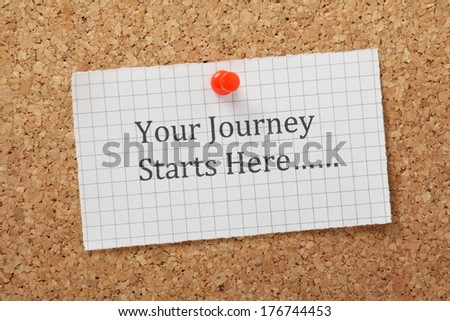 The phrase Your Journey Starts Here typed on a piece of graph paper and pinned to a cork notice board