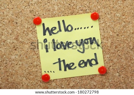 A short story about love. Hello, I Love You, The End written by hand in felt tip pen on a yellow sticky note and pinned to a cork notice board.