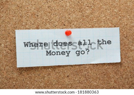 The phrase Where Does All the Money Go? typed on a piece of graph paper and pinned to a cork notice board