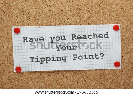 The phrase Have You Reached Your Tipping Point typed on a piece of graph paper and pinned to a cork notice board