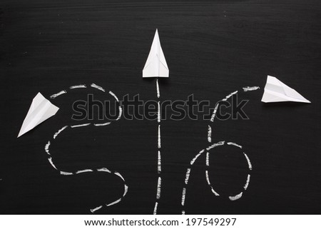 Three paper airplanes take flight in different directions across a blackboard