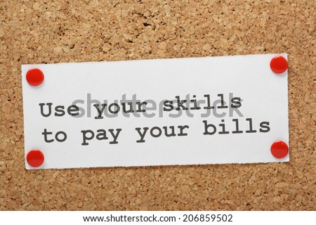 The phrase Use Your Skills to Pay Your Bills on a piece of note paper pinned to cork notice board
