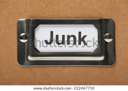 Drawer label in a holder on a cardboard box with the word Junk typed onto the index card