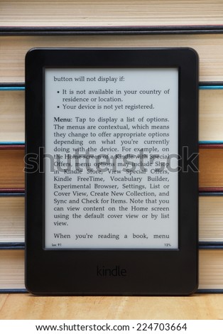 Bracknell, England - October 20th, 2014: A Kindle Touch Reader standing in front of old hardback books. Manufactured by Amazon the device is a portable library of books and other publications