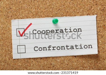 Tick boxes for cooperation versus confrontation on a cork notice board, with a red tick for the right choice in the cooperation box
