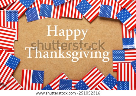 The phrase Happy Thanksgiving in white text on a brown card background with a border of miniature flags of the United States of America