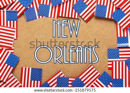 Miniature flags of the United States of America form a border on brown card around the name of New Orleans