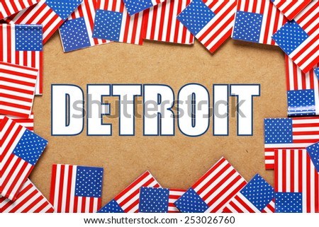 Miniature flags of the United States of America form a border on brown card around the name of the city of Detroit