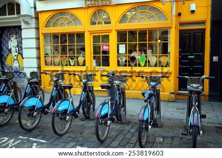 London, England - February 17, 2015: Barclays Bank bicycles parked in a row front of a colorful cafe in London, England. The rental scheme provides over 5000 bikes for hire across the city.