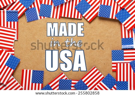 Miniature flags of the United States of America form a border on brown card around the phrase Made in the USA