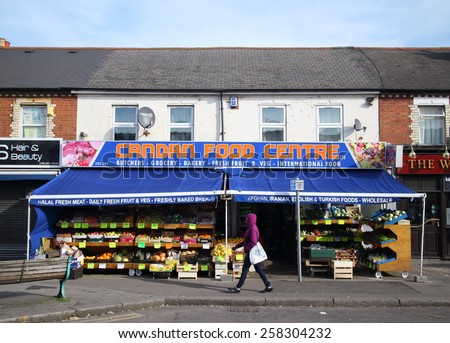 Reading,England - March 6, 2015: A pedestrian passes by an ethnic food supermarket in Reading, England where ethnic peoples can buy Halal meat and International Food alongside traditional groceries.
