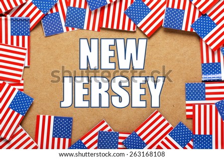 Miniature flags of the United States of America form a border on brown card around the name of the state of New Jersey