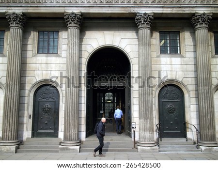 London, England - March 17, 2015: People passing by and entering the doorway of the Bank Of England in London. Also known as The Old Lady of Threadneedle Street, the bank was founded in 1694