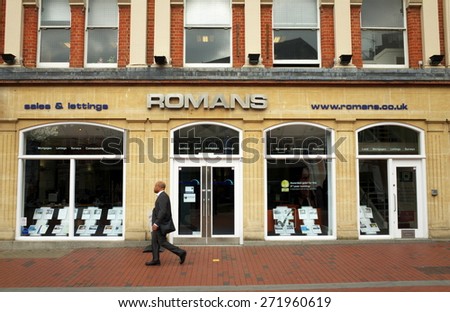 Reading, England - April 23, 2015: A man walks by a Romans Estate Agents window display in Reading, England. According to the Nationwide Building Society, house prices rose over 7% in the UK in 2014