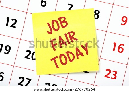 The phrase Job Fair Today on a yellow sticky note attached to a wall calendar as a reminder