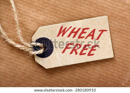 Brown paper label or luggage tag on string with the words Wheat Free in red text