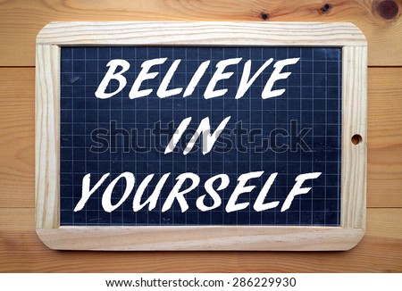 The phrase Believe In Yourself in white text on a slate blackboard