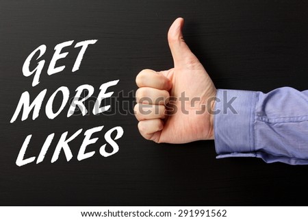 Male hand wearing a business shirt giving the thumbs up sign to the phrase Get More Likes in white text on a blackboard