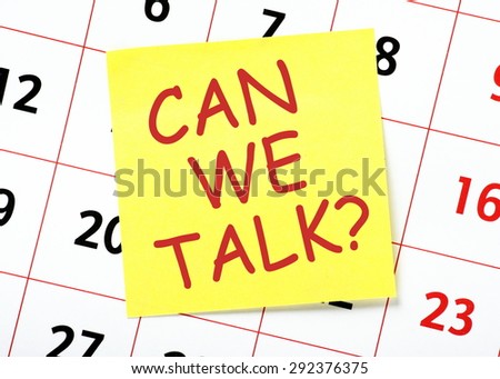 The question Can We Talk? in red text on a yellow sticky note posted on a calendar page as a reminder