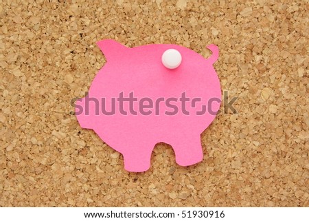 Piggy Bank post it note pinned to a cork background as a reminder to save money