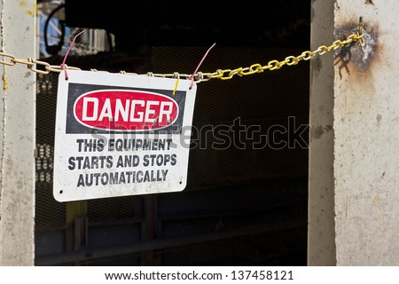 Danger sign is zip tie to a metal chain.