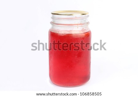Cold jar of homemade plum jelly fresh from refrigerator with condensation sweat dripping against white background.