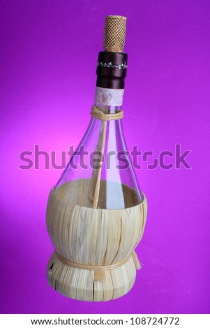 Open bottle of Chianti Wine against pink and purple background.