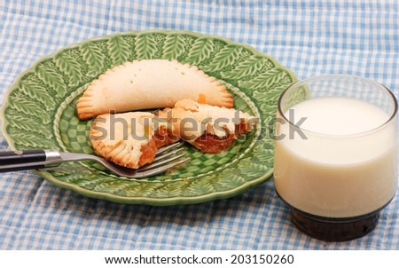 Two Apricot Fried Pies on green plate with small glass of milk.