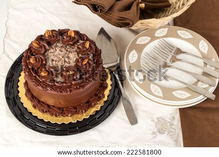 German Chocolate Cake in elegant setting with cake knife and dessert plates.