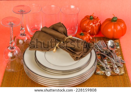 Fine China, silver and crystal on table with Autumn Colors in preparation for Holiday Dinner -- Thanksgiving Colors.