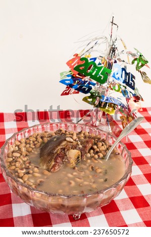 Bow of black eyed peas with ham hock on red plaid tablecloth.  Decorative New Year Center Piece Background.