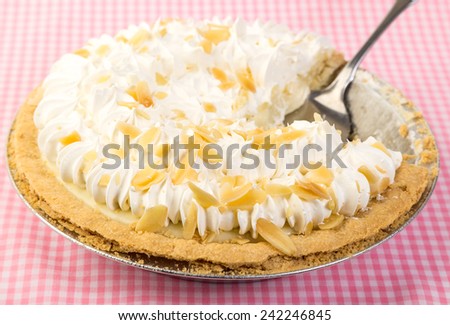Strong back light and selective focus on Banana Cream Pie on Pink Gingham tablecloth.  Country Kitchen Concept.