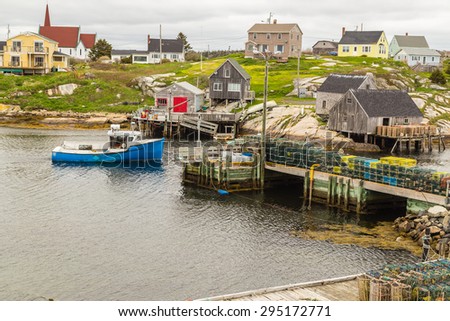 Blue fishing boat returning to harbor at Peggy's Cove Village on coast of Bay of Fundy in Nova Scotia Canada.