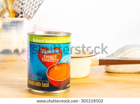 LLANO, TX-AUG 11, 2015:  Can of Progresso Heart Healthy Creamy Tomato with Basil Soup ready for the vintage sauce pan.  Mom's Kitchen Concept.