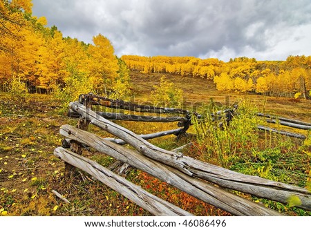 Snow storm imminent as clouds gather over colorful Aspen and split rail fence on Boulder Mountain in Dixie National Forest, Utah.