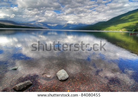 Lake McDonald in Glacier National Park with passing storm cloud reflections and patches of bright sunlight. HDR processing.