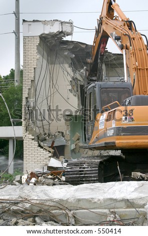 Heavy equipment tearing down a brick building