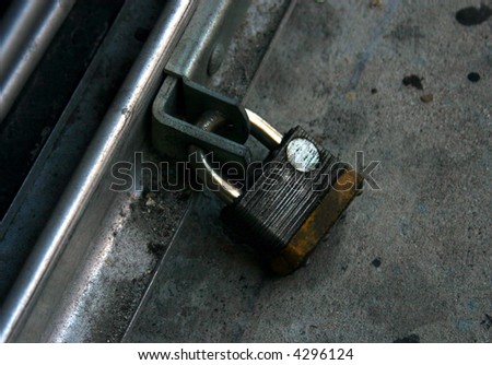 Well-worn padlock on the hasp of a downtown Miami shop security gate PHOTO ID: MiamiStreets00029
