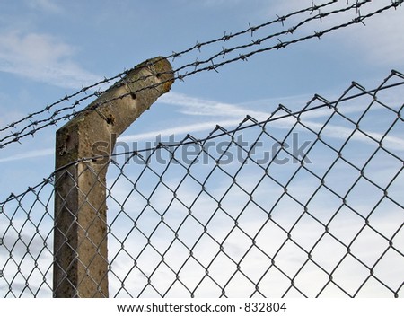 Fence post supporting barbed wire and mesh