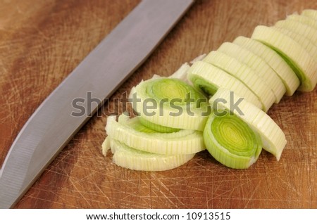Freshly chopped leek on a chopping board with knife
