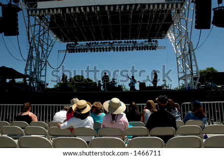 A small audience listens to a band\'s sound check