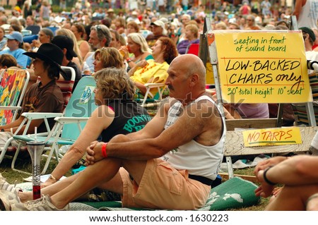 Crowd of people at a concert with a sign \