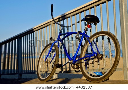 Beach Cruiser style bike parked along a railing at the beach near the Boardwalk at Santa Cruz, California