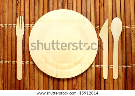 Eco-friendly bamboo plate and silverware on a bamboo place mat -- all renewable compostable materials